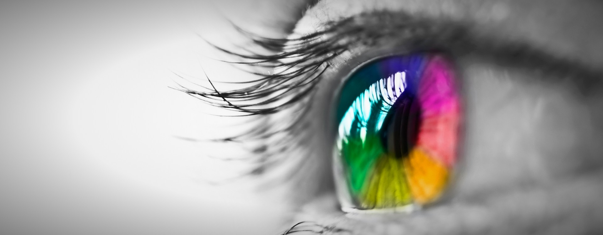 Close-up of an eye with a spectrum of colors reflected in the iris