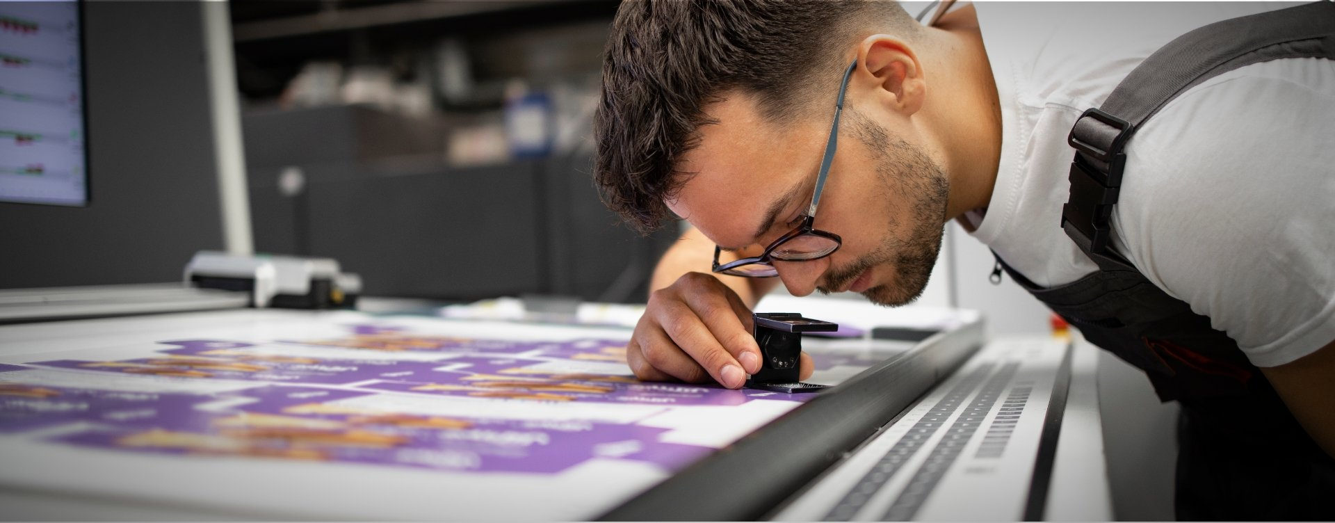 Partnergraf press operator inspecting a freshly printed offset sheet